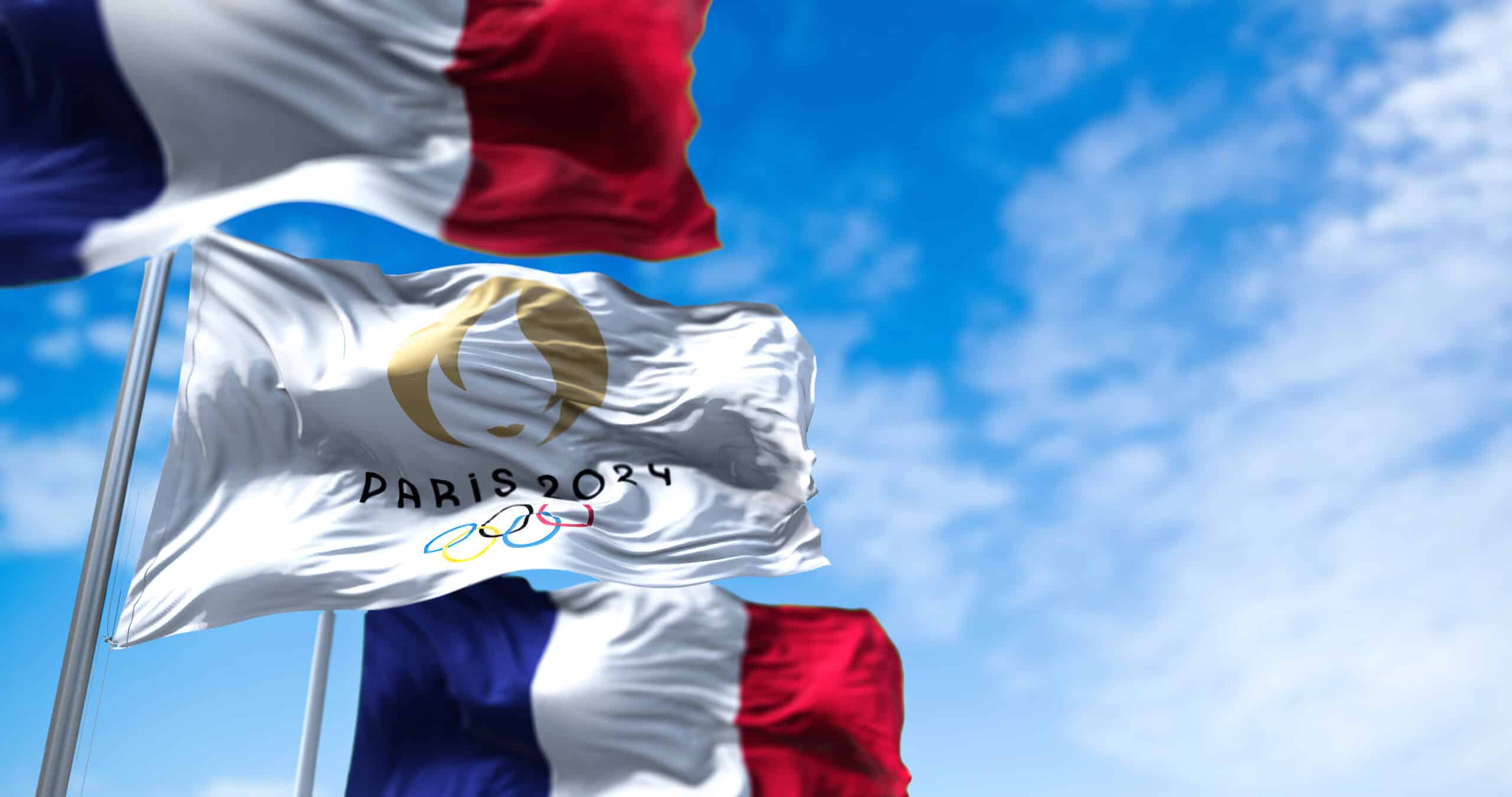 Tokyo, Japan, July 2021: Paris 24 Olympic flag waving in the wind between two French flags. Paris 2024 summer olympics games are scheduled from 26 July to 11 August 2024 in Paris